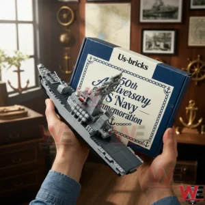 Hands holding a gray brick built warship model with a navy commemoration anniversary box in a nautical themed room!