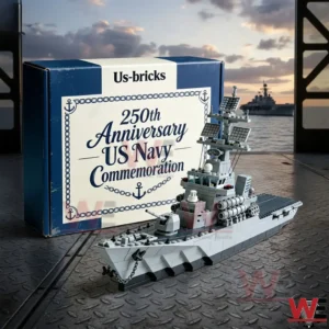 Gray brick built warship model on a metal deck with a navy commemoration box and an ocean warship at sunset in the background!