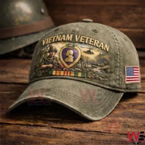 Distressed olive Vietnam Veteran baseball cap with embroidered soldier Purple Heart medal ribbons helicopter scene and a United States flag patch on the side displayed on a wooden surface!