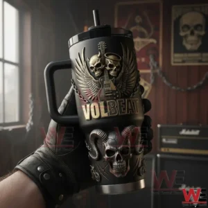 Gloved hand holding a black handled tumbler with embossed skull wings guitar and Volbeat lettering in a rock studio with amplifiers and posters!