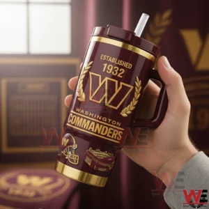 Washington Commanders Tumbler 3 Hand holding a burgundy and gold insulated tumbler with classic sports design details inside a softly lit room!