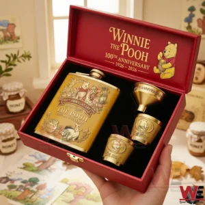 Winnie-the-Pooh 100th Anniversary Flask Gift Set 3 Hands holding a Winnie the Pooh one hundredth anniversary flask gift set with a golden flask and cups in a warm storybook themed setting!