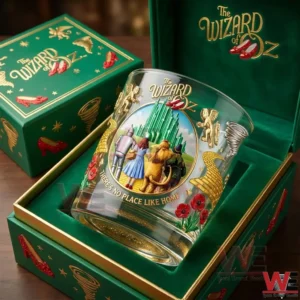 A Wizard of Oz themed whiskey glass resting inside an elegant green gift box with illustrated characters and ornate accents!