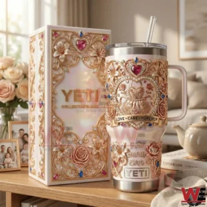 A decorative insulated tumbler and matching gift box with floral heart designs presented on a wooden table in a warm home setting!