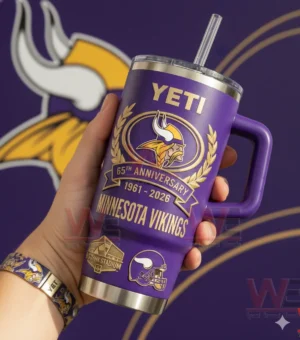 Yeti Minnesota Vikings 1961-2026 65th Anniversary Tumbler 3 Hand holding a purple Minnesota Vikings insulated tumbler with handle and anniversary design in front of a team themed background!