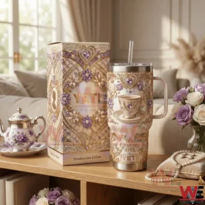 A luxury insulated tumbler with ornate floral heart details stands next to a matching gift box on a styled wooden table!