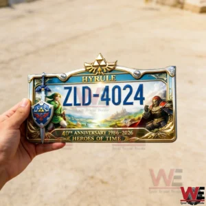 Zelda Hyrule Heroes of Time 40th Anniversary Edition Car License Plate Frame 3 Hand holding a Hyrule themed license plate frame with ZLD four zero two four and gold Triforce crest featuring hero and villain characters with heroes of time anniversary text.