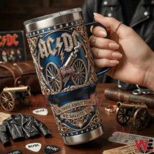 Hand holding blue ACDC cannon tumbler with ornate details and rock themed background!