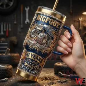 Hand holding a Bigfoot monster truck themed tumbler inside a mechanic workshop!