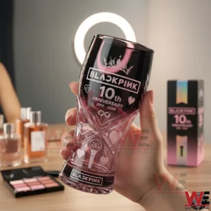 Hand holding Blackpink tenth anniversary pink and black commemorative glass indoors!