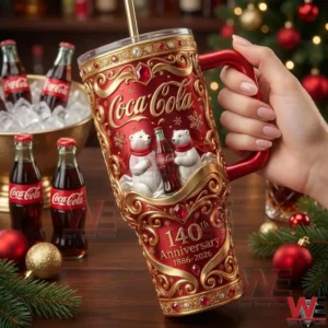Hand holding a red and gold Coca Cola anniversary tumbler with holiday background!