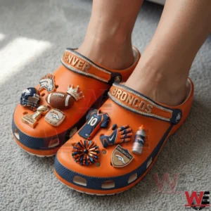 Person wearing orange Denver Broncos clogs with football themed charms!