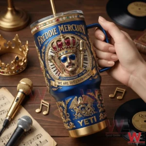 Hand holding a blue and gold Freddie Mercury themed insulated tumbler on a music themed table!