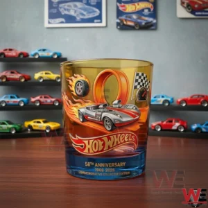 Hot Wheels anniversary whiskey glass on a wooden table with model cars behind!