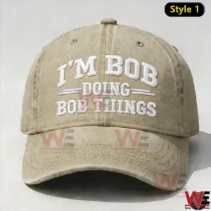 Beige baseball cap with white embroidered text I M BOB DOING BOB THINGS on the front.