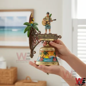 Hands holding a Jimmy Buffett themed wall mounted bell with a guitar player figure a parrot and a tropical painted bell!