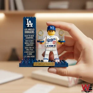 Hand holding brick built Los Angeles Dodgers player with two championship trophies.