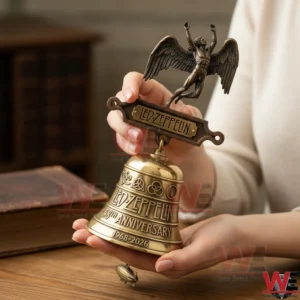 Hands holding a Led Zeppelin commemorative bell with a winged figure topper!