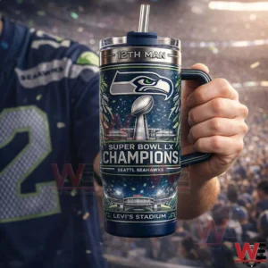 Hand holding a Seattle Seahawks themed tumbler with handle and straw in a stadium setting!