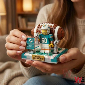 Hands holding Miami Dolphins brick football anniversary display with trophies and football backdrop!