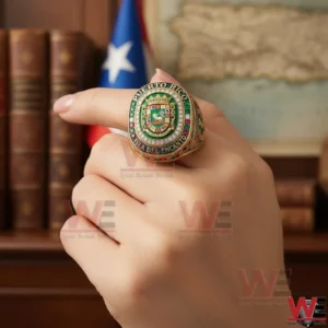 Close up of a gold Puerto Rico crest ring worn on a hand with flag in background.