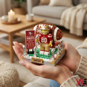 Hands holding San Francisco Forty Niners brick football anniversary display with trophies and football backdrop!