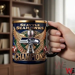 Hand holding Seattle Seahawks Champions navy and gold mug in front of bookshelf.
