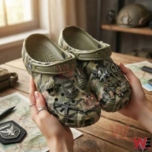 Hands holding camouflage SWAT themed clogs with tactical charms!
