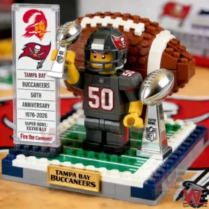 Brick football player in Tampa Bay Buccaneers uniform holding two championship trophies beside a fifty th anniversary display on a small field base!
