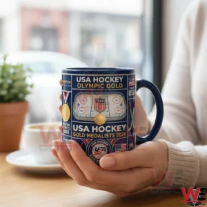 Hand holding a USA Hockey Olympic Gold 2026 themed mug in a cafe!