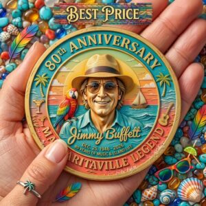 A hand holds a colorful commemorative Jimmy Buffett 80th anniversary coin over a bed of turquoise stones and sea shells!