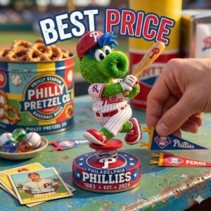 A high quality promotional image showing a green Phillies mascot figure in a uniform and cap on a custom base on a textured table with a hand holding a miniature pennant and surrounded by vintage Phillies branded merchandise like a pretzel tin, old cards, and marbles under large Best Price text!