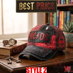 A red and black AC DC baseball cap on a desk with a watch keys and plant!