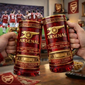 Two Arsenal anniversary mugs held up in front of a television showing football players!