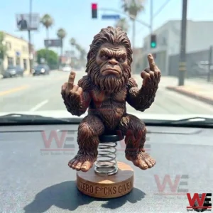 Bigfoot bobblehead on a car dashboard making a rude hand gesture!