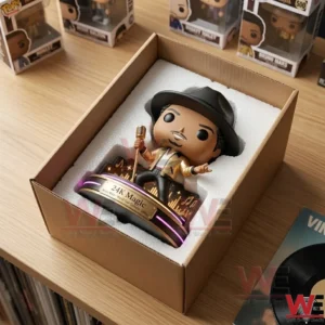 Bruno Mars 24k Magic Pop Figure Doll 5 An open brown cardboard shipping box containing a pop-culture vinyl figure on a light wooden table! The figure of a male singer in a black hat and gold jacket holding a microphone is secured in white styrofoam padding! The figure is on its tiered stand which has lit purple neon rings and a 24K Magic plaque! Several other similar boxed figures are visible on a shelf in the background! A framed black vinyl record sits on the table surface next to the box!