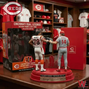 A detailed collectible statue of Anthony Munoz and Pete Rose doing a fist bump on a red base with the city skyline displayed next to its original packaging box!