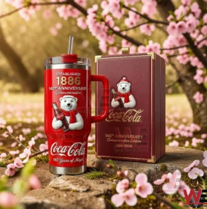 Red Coca Cola anniversary tumbler with straw next to a matching gift box in a pink blossom setting!