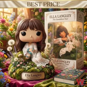 A collectible vinyl figure of a woman in a lace dress sitting on a mossy base with a gold plaque! Behind it is the product box showing the name Ella Langley and a portrait! A hardcover book is in the foreground on a purple cloth! The entire composition is surrounded by assorted garden flowers and plants!