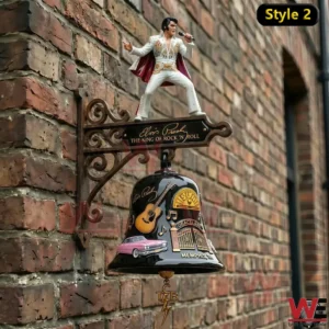 Black wall bell with rock and roll artwork and performer figure mounted on brick wall.