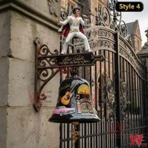 Black wall bell with performer figure and rock themed artwork mounted near iron gate.