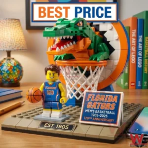 A commemorative Florida Gators brick building set showing an alligator mascot jumping through a basketball rim. A small basketball player figure stands on a gray base next to an anniversary sign on a wooden desk.