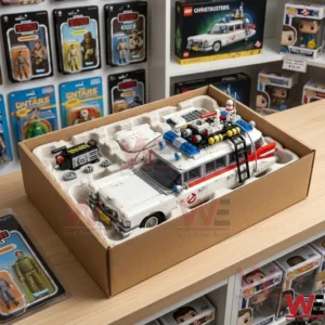 A completed Ecto 1 building set is packed in a cardboard box with a protective tray. The box sits on a wooden shelf in a store surrounded by many other boxed and carded toys.