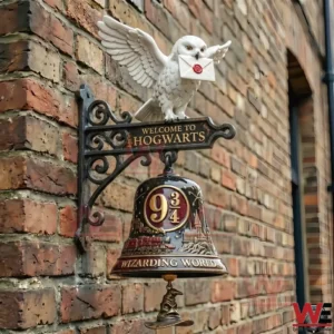 Hogwarts wall bell with white owl holding letter and Platform nine and three quarters emblem on brick wall.