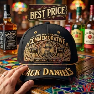 A black Jack Daniels commemorative cap with gold embroidery sits on a mosaic table! The hat features a central portrait logo and large gold lettering on the brim with whiskey bottles in the background!