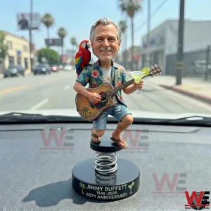 Jimmy Buffett anniversary bobblehead on a car dashboard with guitar parrot and drink!