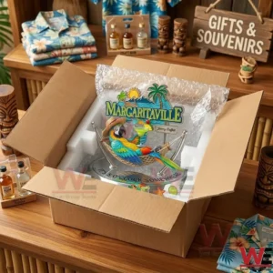Jimmy Buffett Margaritaville Car Hood Ornament 3 An open cardboard box containing a Margaritaville parrot figurine with foam packaging! The box is on a wooden table in a shop with tropical shirts and tiki statues!