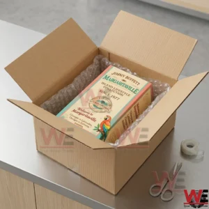 A branded gift box placed inside a cardboard shipping container with protective bubble wrap on a table!