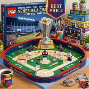 A detailed brick building set of a baseball field commemorates the Venezuela WBC 2026 championship. The model includes a silver trophy small player figures and a scoreboard showing the winning score. It sits on a desk with a themed mug and glasses.