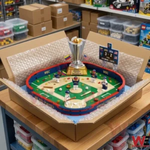An assembled brick model of the Venezuela baseball championship stadium is packed in a cardboard box with bubble wrap. The box is on a wooden table in a storage room with many shelves and bins.